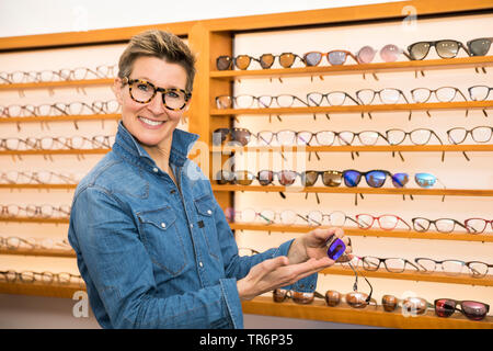 Femme dans un magasin de lunettes, Allemagne Banque D'Images