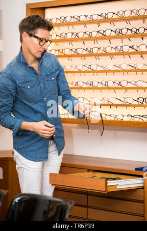 Femme dans un magasin de lunettes, Allemagne Banque D'Images