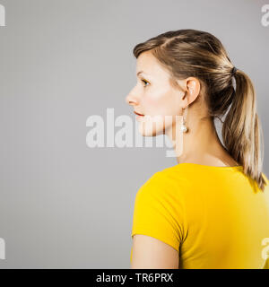 Belle femme en T-shirt jaune, vue latérale, Allemagne Banque D'Images