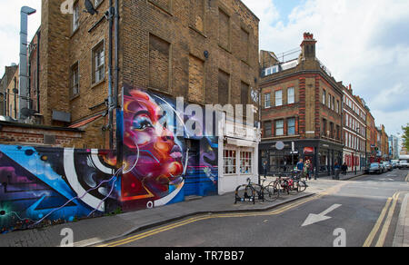 Londres SPITALFIELDS ZONE GAFFITI BRICK LANE ET L'ART DE MUR EN BRIQUE ET RUE HANBURY PLUSIEURS MAISONS Banque D'Images