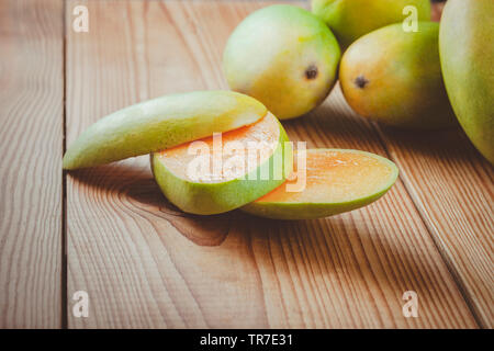 Close-up of fresh green Dashehari les mangues et ses tranches mis sur table en bois. Banque D'Images