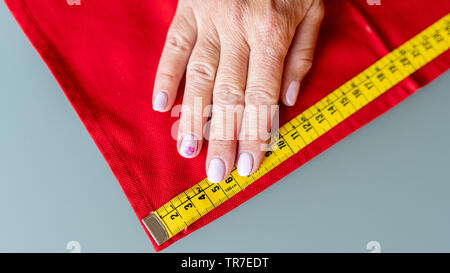 La mesure d'une femme à la main avec du tissu au mètre. Banque D'Images