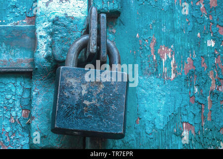 Cadenas fermé sur Vintage moraillons porte peint rayé. Concept de sécurité et de protection de la vie privée. Grunge fond texturé Banque D'Images