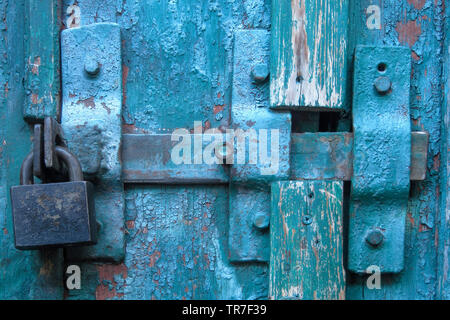 Vintage et de verrouillage cadenas fermé sur weathered rayé porte en bois. Concept de sécurité et de protection de la vie privée. Grunge fond texturé Banque D'Images