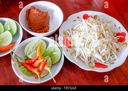 Accompagnement avec curry au chili et à la lime et fèves germées pour garnir la soupe aux nouilles asia food sur la table Banque D'Images