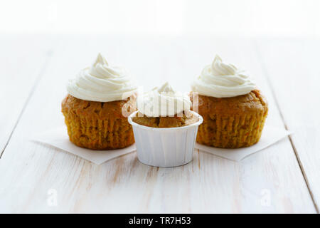 Cupcakes avec glaçage vanille carotte. Table en bois blanc, haute résolution Banque D'Images