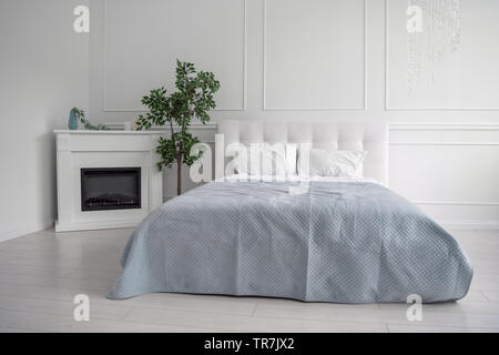 Vue avant du cuir blanc lit dans cette chambre blanche Banque D'Images