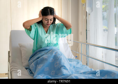 Jeune femme asiatique les patients se trouvant dans la salle. Les patients asiatiques avaient des maux de tête à l'hôpital. Banque D'Images