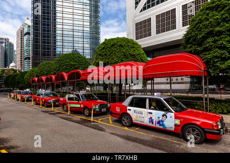 Une ligne de taxis rouges et blancs, de Hong Kong, Chine Banque D'Images