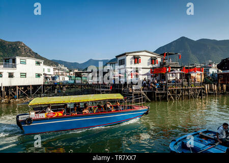 Un voyage en bateau touristique passe d'un restaurant sur pilotis, village de pêcheurs Tai O, Hong Kong, Chine Banque D'Images