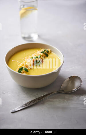 Soupe de fromage à la crème jaune avec des germes de pois dans un bol Banque D'Images