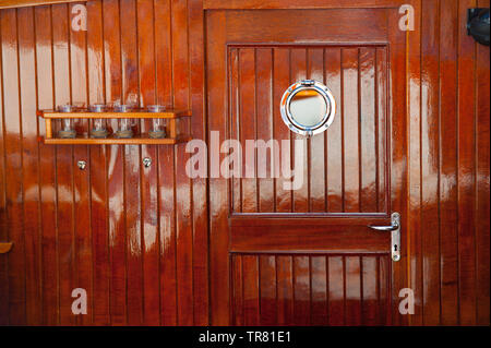 Détails délicats de la plate-forme sur un bateau en bois. Une porte et un porte-gobelet. Banque D'Images