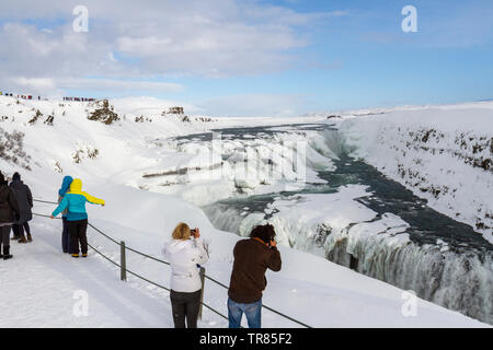 Les touristes alignés en admirant les superbes chutes de Gullfoss sur la rivière Hvítá dans le sud de l'Islande. Banque D'Images