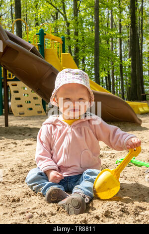 15 mois adorable blond caucasian toddler playing sur carré de sable à l'intérieur du parc public piscine Sorel-Tracy Québec Canada jouant sur le sable fort à la publ Banque D'Images