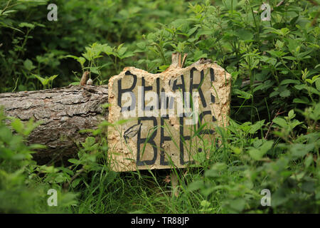 Avertissement signe des ruches dans un bois. Banque D'Images