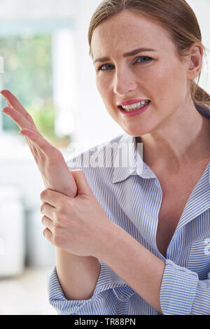 Portrait de femme en souffrance avec la douleur du poignet Holding Répétitifs Banque D'Images