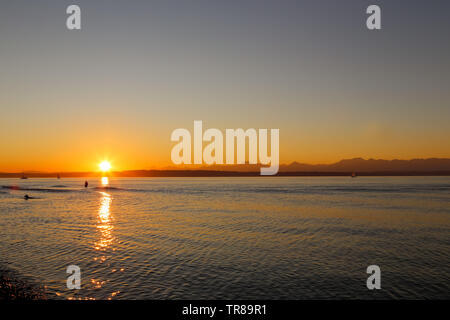 La pêche est un pêcheur Golden Gardens Park, Seattle, Washington au cours d'un magnifique coucher de soleil Banque D'Images