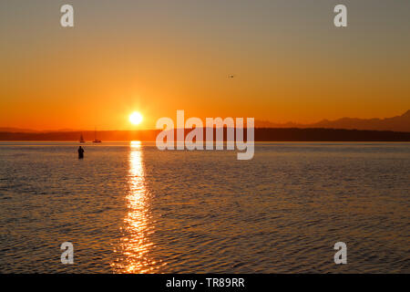 La pêche est un pêcheur Golden Gardens Park, Seattle, Washington au cours d'un magnifique coucher de soleil Banque D'Images