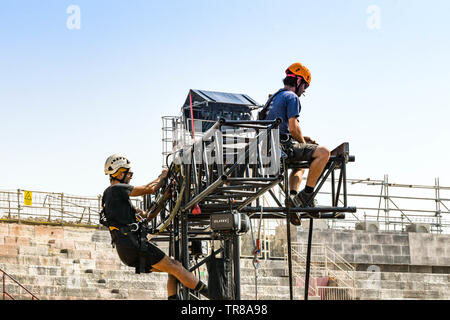 Vérone, Italie - Septembre 2018 : les monteurs spécialisés sur le haut d'un grand bras d'éclairage en métal du démontage du cadre après un concert dans les arènes de Vérone Banque D'Images