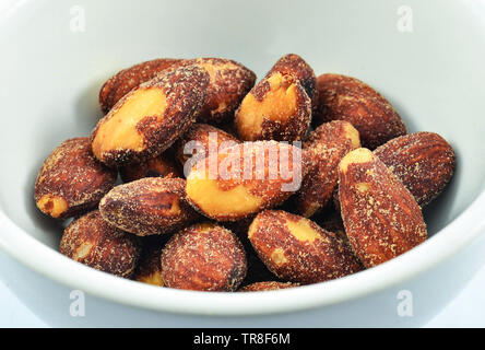 L'écrou d'Amandes sel cuire les graines dans un bol isolé sur fond blanc Banque D'Images