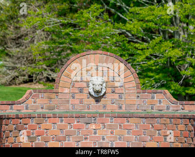 Fontaine Lions Head avec des briques dans un paysage vert Banque D'Images