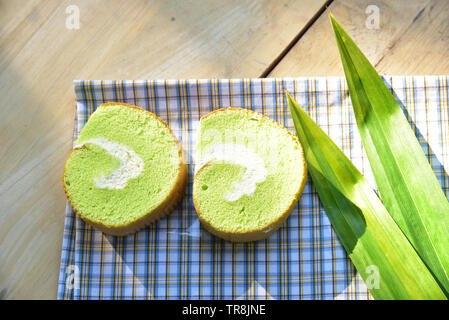 Crème de Pandan gâteau à la boulangerie-pâtisserie rouleau sur du tissu avec de la crème fraîche et la feuille de Pandan Banque D'Images