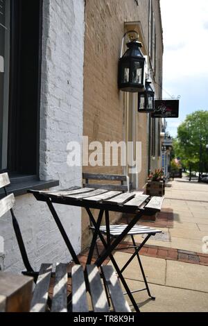 Ensemble Bistro sur un trottoir du centre-ville à l'été au cours de la journée, avec un bâtiment en arrière-plan Banque D'Images