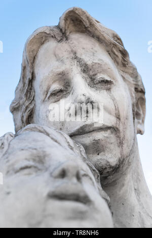 Statue d'une mère et son fils contre le ciel bleu Banque D'Images