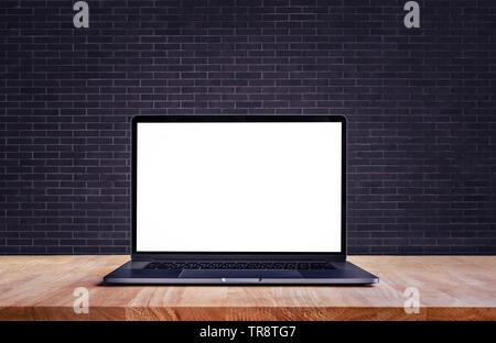 Ordinateur portable moderne,avec écran vide sur table et mur de brique d'artifices,pour la présentation et la communication des idées Banque D'Images
