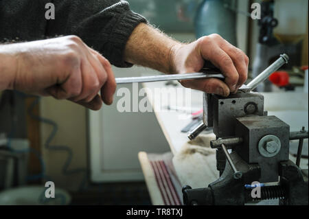 La réparation d'un injecteur mécanique diesel. La main de l'homme tenant une clé dynamométrique et untwists détails coincé dans un étau. Banque D'Images