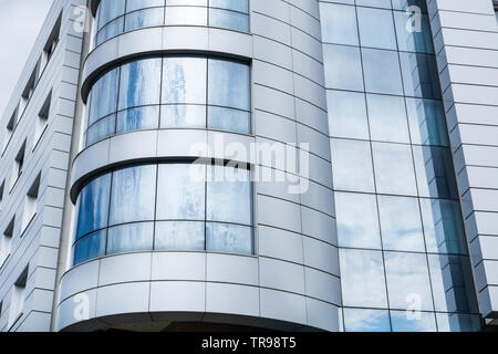 Bâtiment moderne façade propre et windows avec ciel nuageux la réflexion. L'architecture moderne et l'extérieur concept. Close up, selective focus Banque D'Images