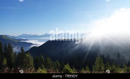 Belle matinée dans les montagnes avec le brouillard dans la vallée et le soleil sur la montagne Banque D'Images