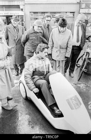 L'Angleterre. 10 janvier 1985. Le lancement de la Sinclair C5, véhicule électrique ou velomobile, conçu par Sir Clive Sinclair. Les membres du public se rassembler autour du véhicule pour donner leur avis. Un homme montre le véhicule. Banque D'Images