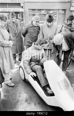 L'Angleterre. 10 janvier 1985. Le lancement de la Sinclair C5, véhicule électrique ou velomobile, conçu par Sir Clive Sinclair. Les membres du public se rassembler autour du véhicule pour donner leur avis. Un homme montre le véhicule. Banque D'Images