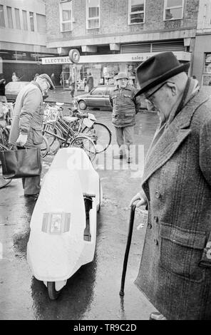 L'Angleterre. 10 janvier 1985. Le lancement de la Sinclair C5, véhicule électrique ou velomobile, conçu par Sir Clive Sinclair. Les membres du public se rassembler autour du véhicule pour donner leur avis. Banque D'Images