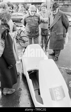 L'Angleterre. 10 janvier 1985. Le lancement de la Sinclair C5, véhicule électrique ou velomobile, conçu par Sir Clive Sinclair. Les membres du public se rassembler autour du véhicule pour donner leur avis. Banque D'Images