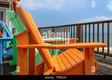 Des gouttes de colle sur un ensemble de chaises Adirondack colorés après une tempête en Canard, North Carolina, USA. Banque D'Images