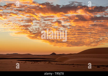 Un magnifique coucher de soleil africain dans l'ouest du désert du Soudan avec des nuages et du ciel et l'appartement désert paysage Banque D'Images