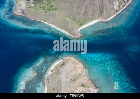 Vu d'une vue aérienne, un canal étroit, entourées de récifs coralliens, passe entre les îles tropicales dans le Parc National de Komodo, en Indonésie. Banque D'Images