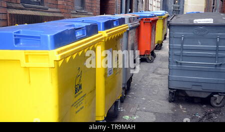 Les Poubelles de déchets commerciaux bloquer une allée dans le centre-ville de Manchester, Royaume-Uni Banque D'Images