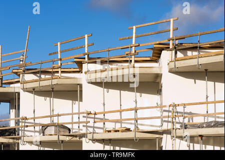 Détail d'une construction d'une maison avec des murs en béton, d'un balcon et d'un échafaudage. Banque D'Images