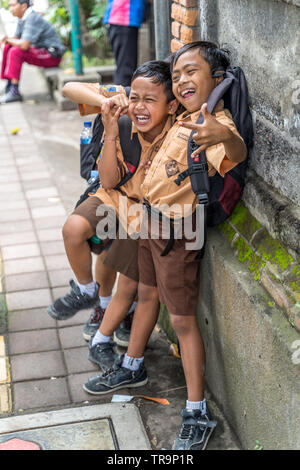 Ubud, Bali, Indonésie - Janvier 2019 : les garçons en uniforme d'jouant sur la rue d'Ubud Banque D'Images