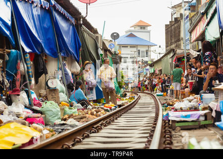 Shopping le long de la voie ferrée au marché ferroviaire Maeklong, Bangkok, Thaïlande Banque D'Images