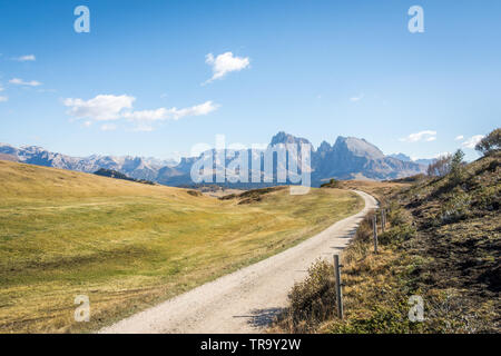 Une longue et sinueuse route de gravier située sur les Dolomites en Italie du nord sur une journée ensoleillée avec un ciel bleu et une excellente visibilité. Banque D'Images