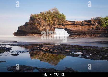 Naturellement magnifique arc de roche altérée Batu Bolong partie du célèbre temple de Tanah Lot à Bali, Indonésie. Seascape grand angle droit Banque D'Images