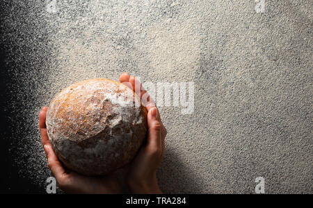 Les mains tiennent pain frais mise à plat avec l'exemplaire de l'espace. La texture de la farine. Sans gluten régime sain concept. Banque D'Images