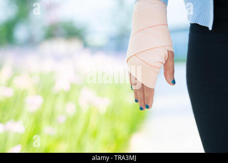 Attelle de bras, main de femme blessée avec le bas du corps. En tissu élastique avec un bandage à la main Banque D'Images