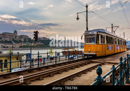 Les transports publics de Budapest. Un vieux tram trundles le long du Danube au coucher du soleil Banque D'Images