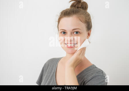 Young caucasian woman nettoyer le visage avec une lingette, retrait de Banque D'Images