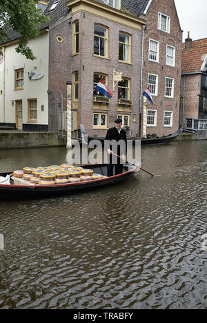 Un fromage fermier dans la ville néerlandaise d'Alkmaar transportant ses fromages sur un petit bateau dans les canaux Banque D'Images